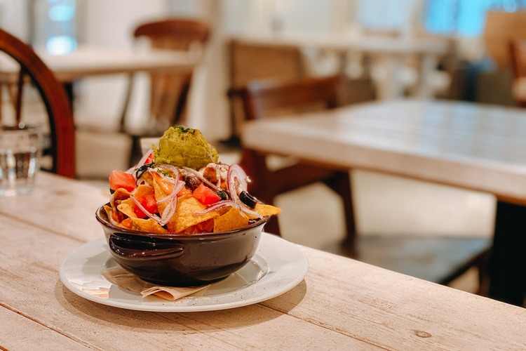 Nachos Recipe - Tortilla Chips and Guacamole Bowl with Tomatoes, Olives and Red Onions